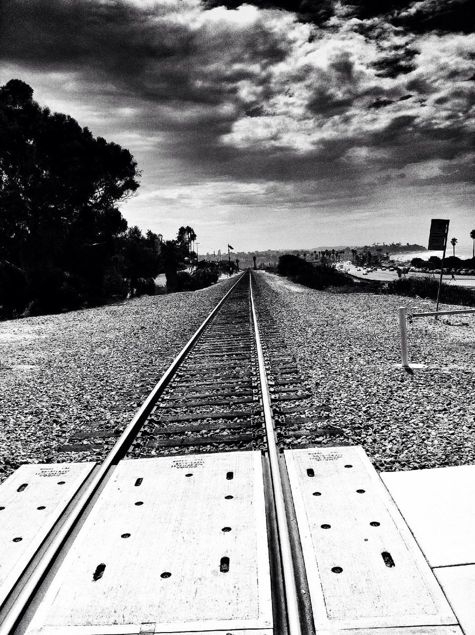 railroad track, rail transportation, the way forward, sky, transportation, diminishing perspective, vanishing point, public transportation, built structure, railway track, cloud - sky, architecture, building exterior, tree, high angle view, day, cloud, outdoors, straight, no people