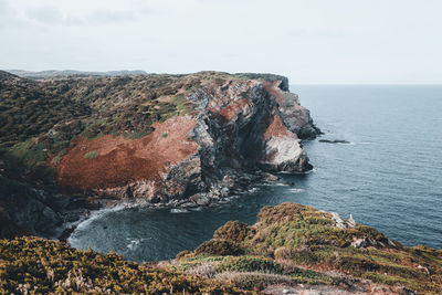 Rock formations by sea against sky