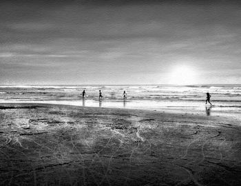 Silhouette people on beach against sky