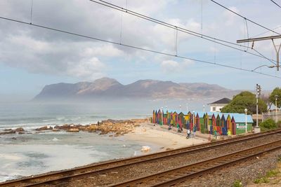 Scenic view of sea by mountains against sky