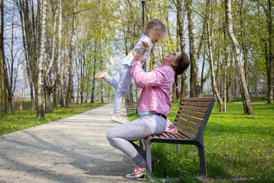 The fun of lifting a four-year-old daughter up in a city park.