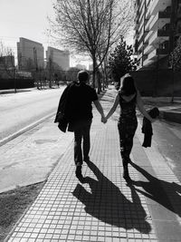 People walking on footpath in city