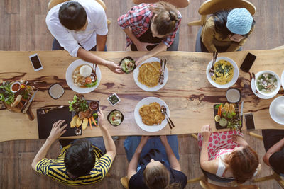 High angle view of people sitting on dining table