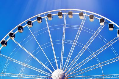 Low angle view of ferris wheel against blue sky