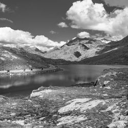 Scenic view of lake by snowcapped mountains against sky