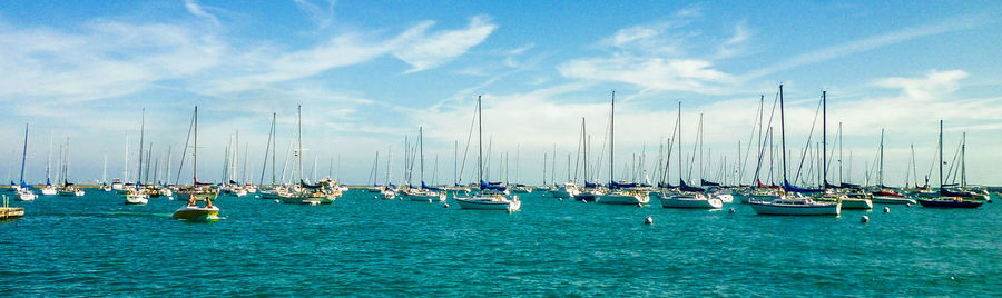 Sailboats in sea against sky