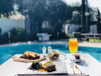 Breakfast served on table against swimming pool