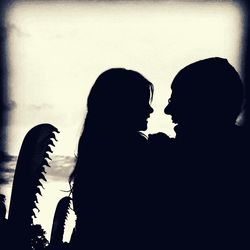 Close-up of silhouette couple against sky