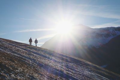 People on mountain against sky