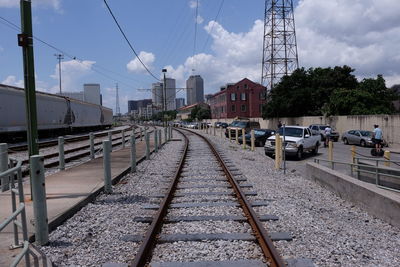 Railroad tracks in city against sky