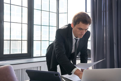 Side view of businessman using laptop at office