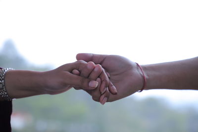 Cropped image of couple holding hands