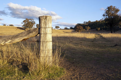 Wooden fence on field against sky