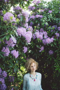 Portrait of woman against purple flowering plants