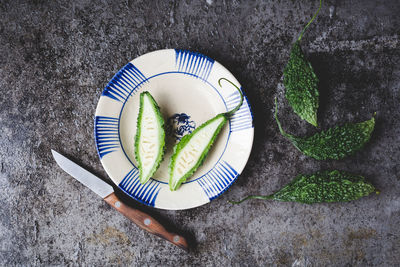 Directly above shot of bitter gourds with slices on table