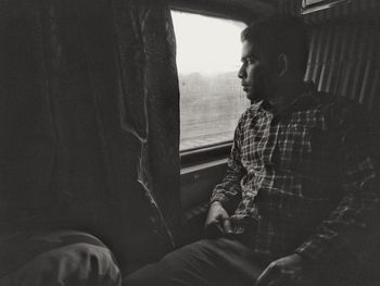 Man looking through window in train