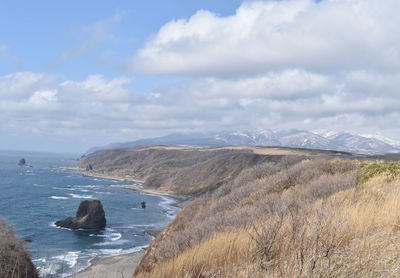 Scenic view of sea and mountains against sky