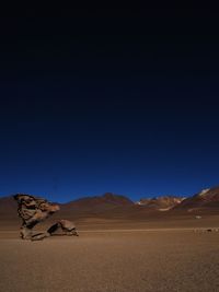 Scenic view of desert against clear blue sky