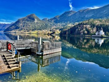 Scenic view of lake with landing stage and mountains against sky