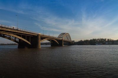 Bridge over river against sky in city