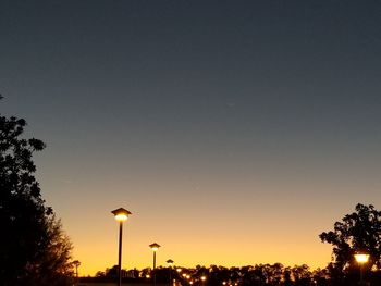 Low angle view of illuminated street light against clear sky