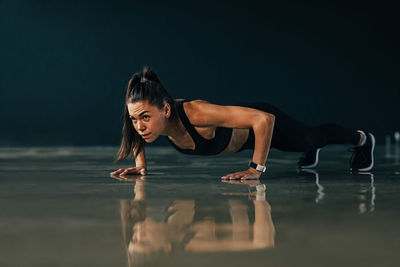 Full length of woman exercising on floor