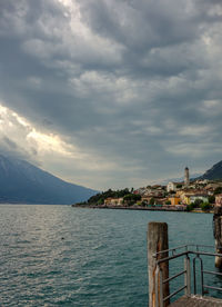 Scenic view of sea by buildings against sky