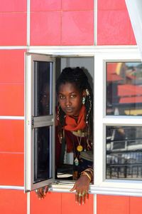 Portrait of woman looking through window