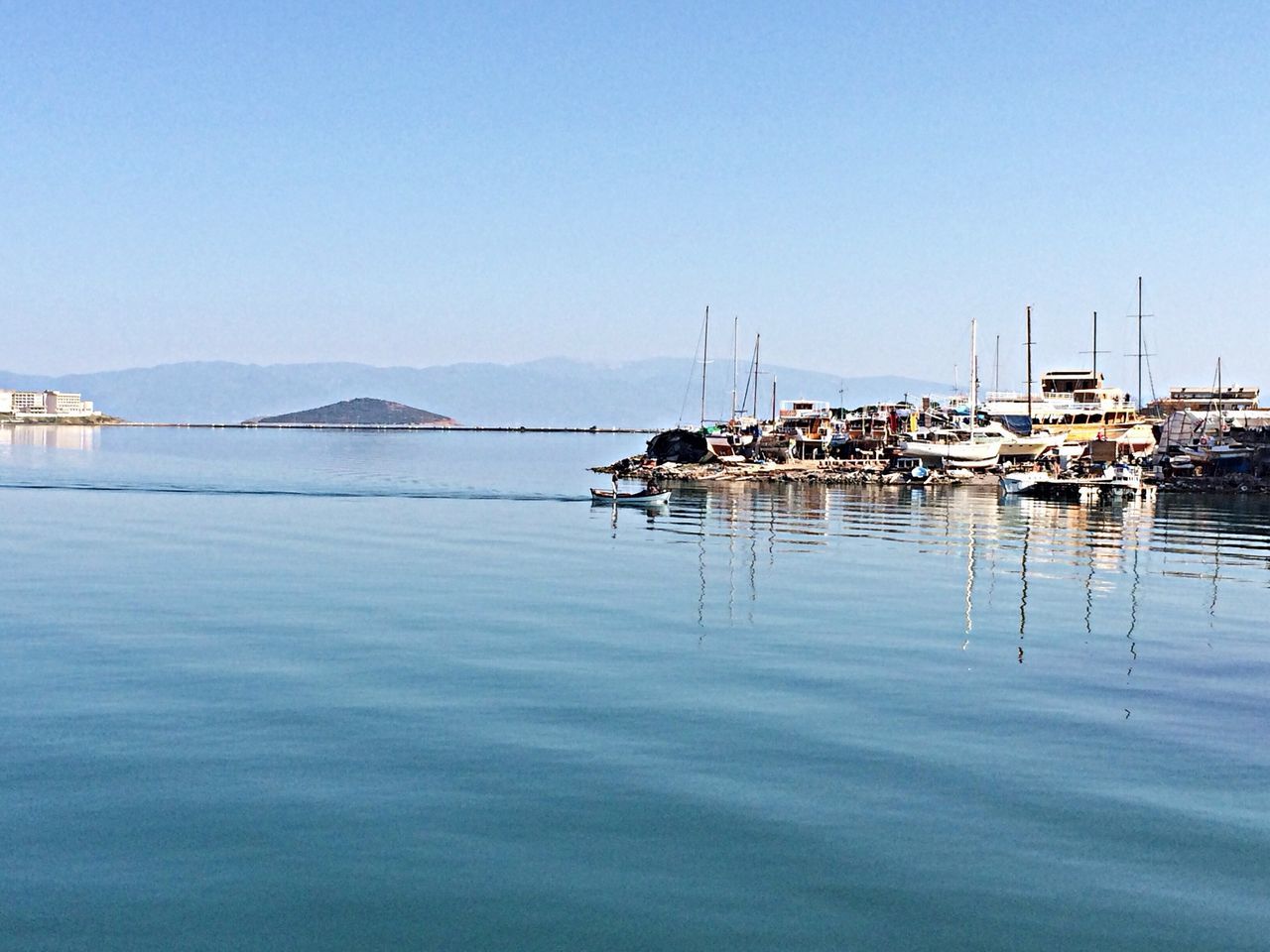 water, clear sky, copy space, waterfront, tranquil scene, tranquility, lake, blue, reflection, sea, nautical vessel, moored, nature, scenics, beauty in nature, mountain, boat, pier, harbor, calm