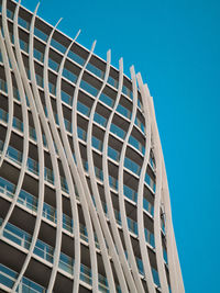 Low angle view of modern building against clear blue sky