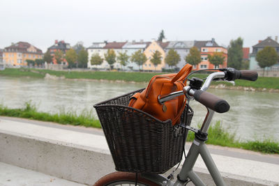 Travel to salzburg, austria. a bicycle on a view of a park, a river and mountains.