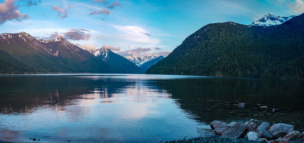 Scenic view of lake by mountains against sky