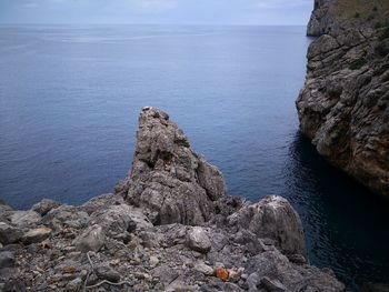 Rock formation in sea against sky