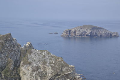 Rock formations in sea against sky
