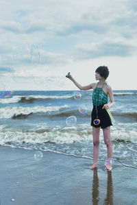 Rear view of woman standing at beach