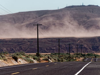 Road by mountains against sky