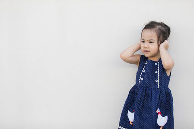 Cute girl standing against white background