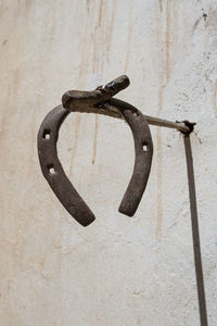 Close-up of rusty chain hanging on wall