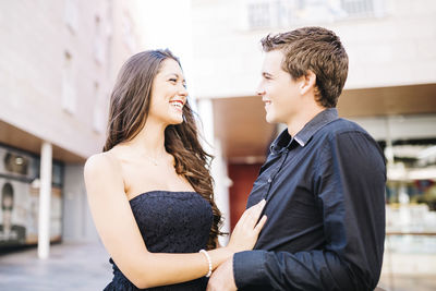 Young couple standing against wall