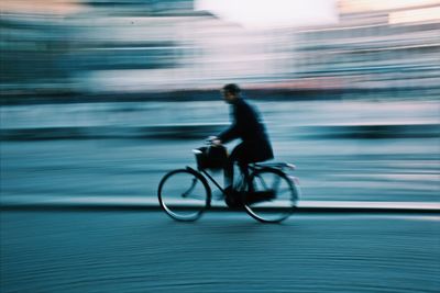 Man riding bicycle on street in city