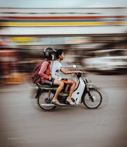 Side view of woman riding motorcycle