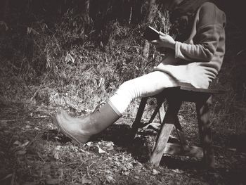 Man using mobile phone while sitting on field