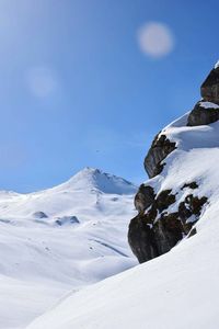 Scenic view of snowcapped mountains against clear blue sky