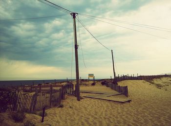 View of fence against cloudy sky