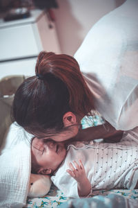 Mother kissing baby at home