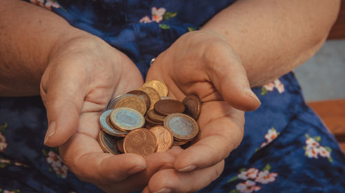 Midsection of person holding coins