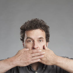 Close-up portrait of man against gray background