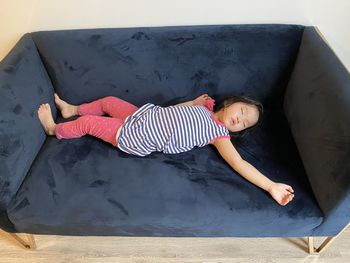 High angle view of woman lying on sofa