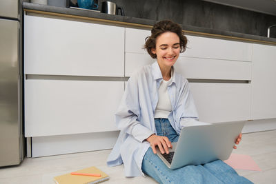 Portrait of young businesswoman using laptop while sitting at home