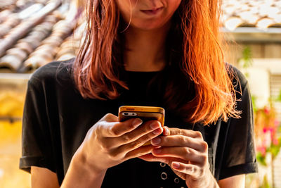 Midsection of woman using mobile phone